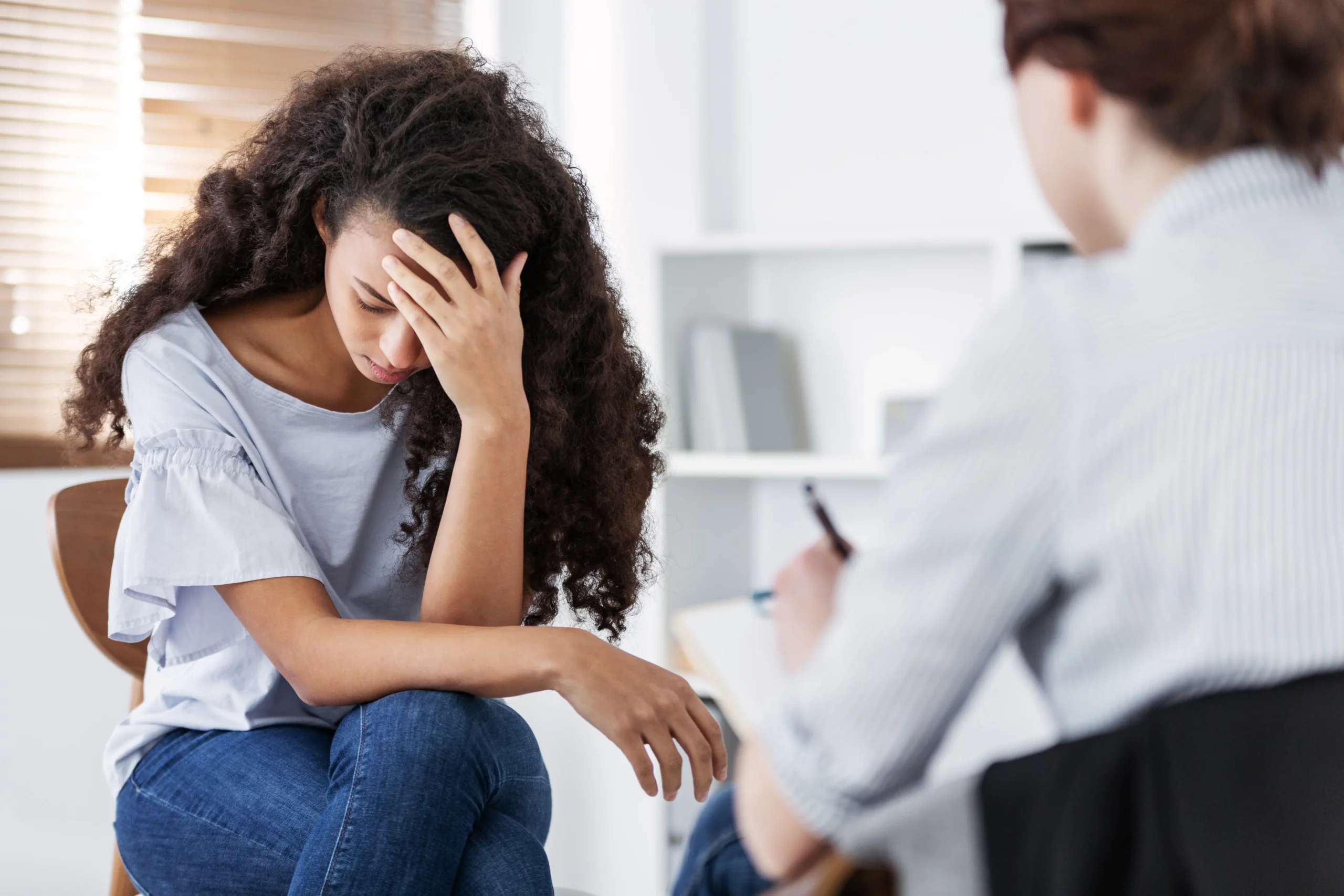 curly-haired young woman with anorexia nervosa in a therapy session for eating disorder