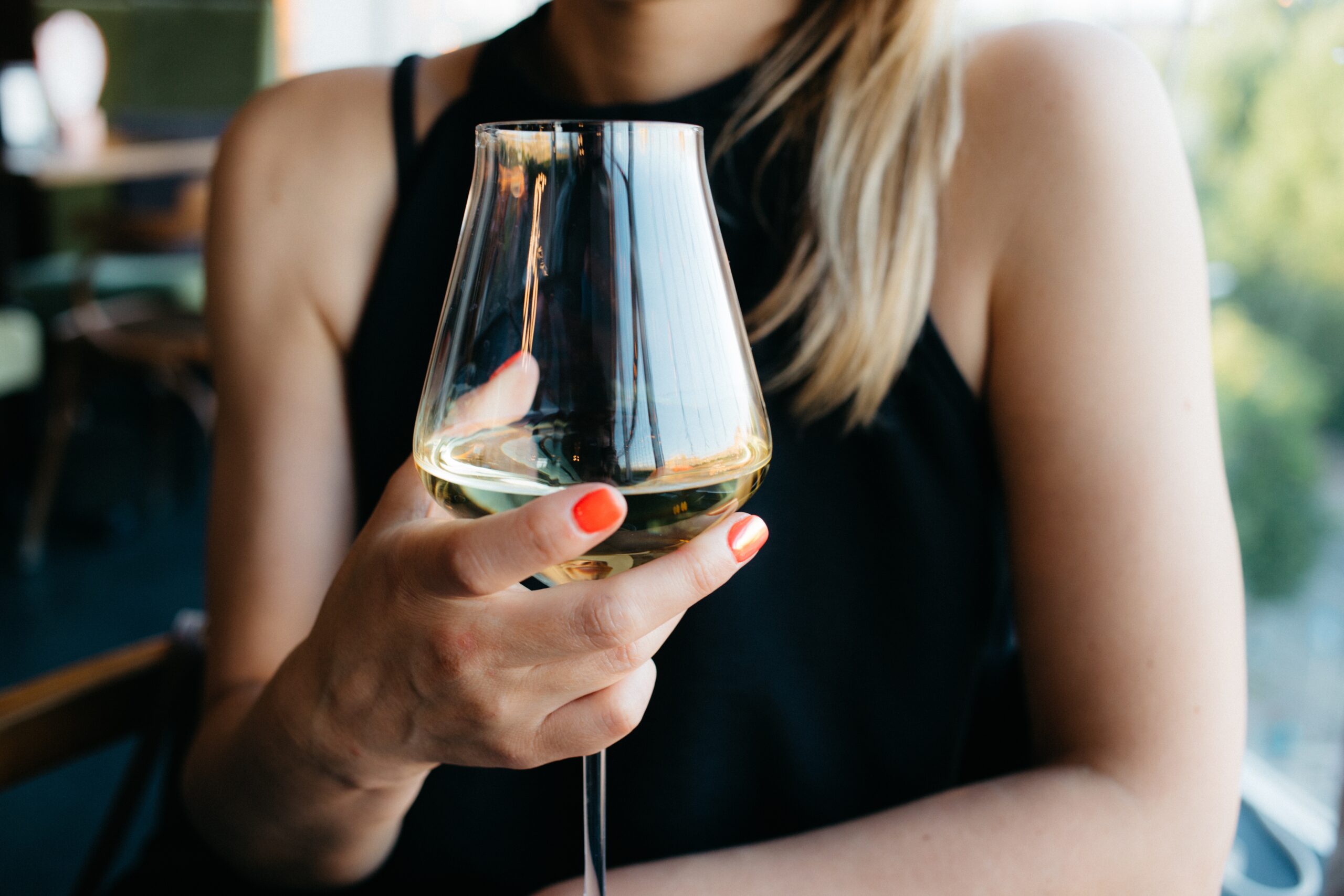 woman with drunkorexia holding a glass of white wine