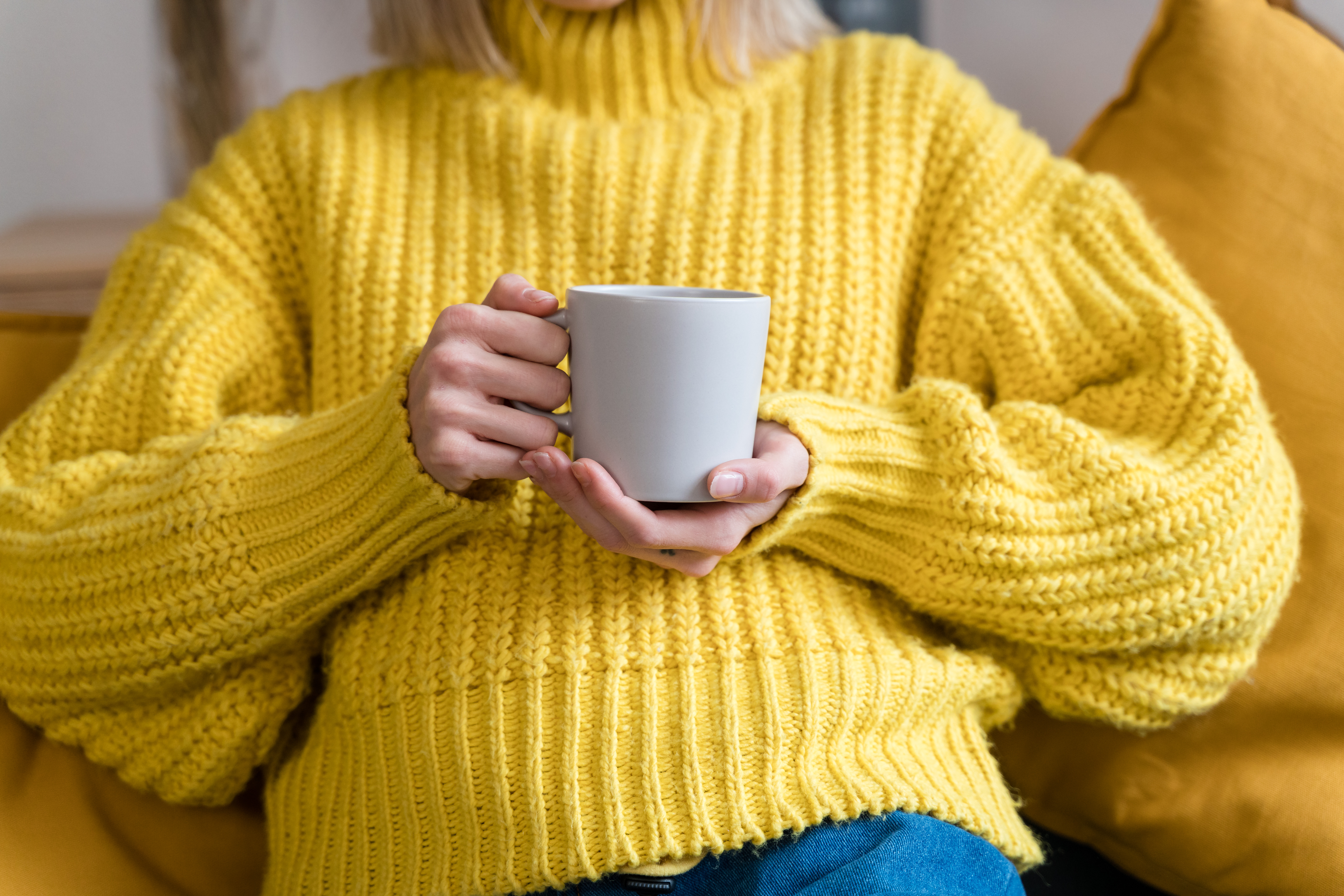 woman in yellow sweater holding a mug hiding her bulimia hands